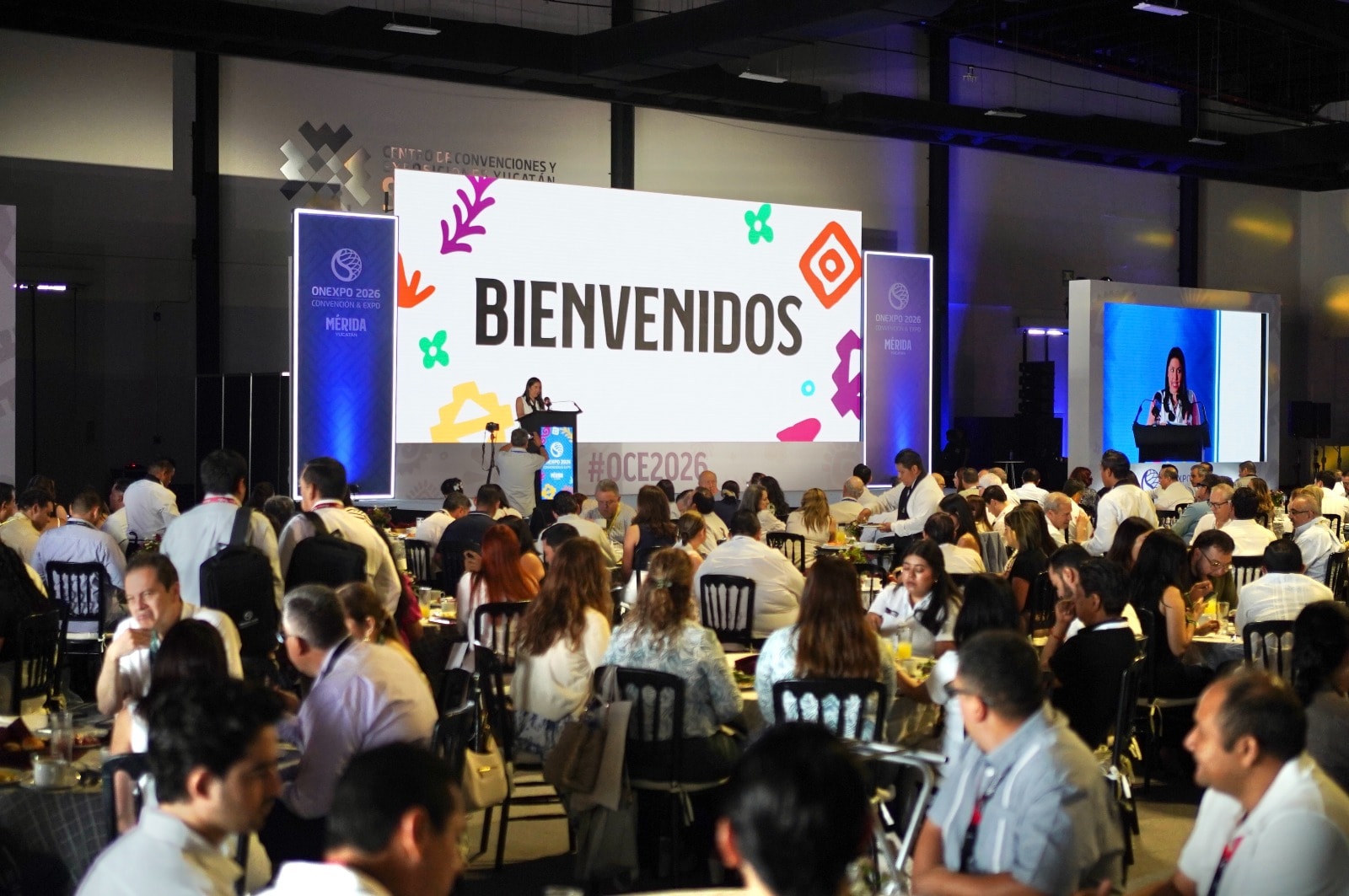 Convención con público, escenario y pantalla LED